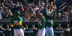 Oakland A's batters celebrating a run crossing home