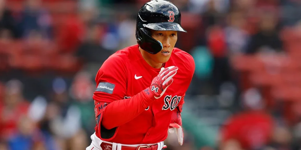 Minneapolis, Minnesota, on June 20, 2023. Masataka Yoshida of the Boston  Red Sox is congratulated by teammates in the dugout after hitting a two-run  home run in the eighth inning of a